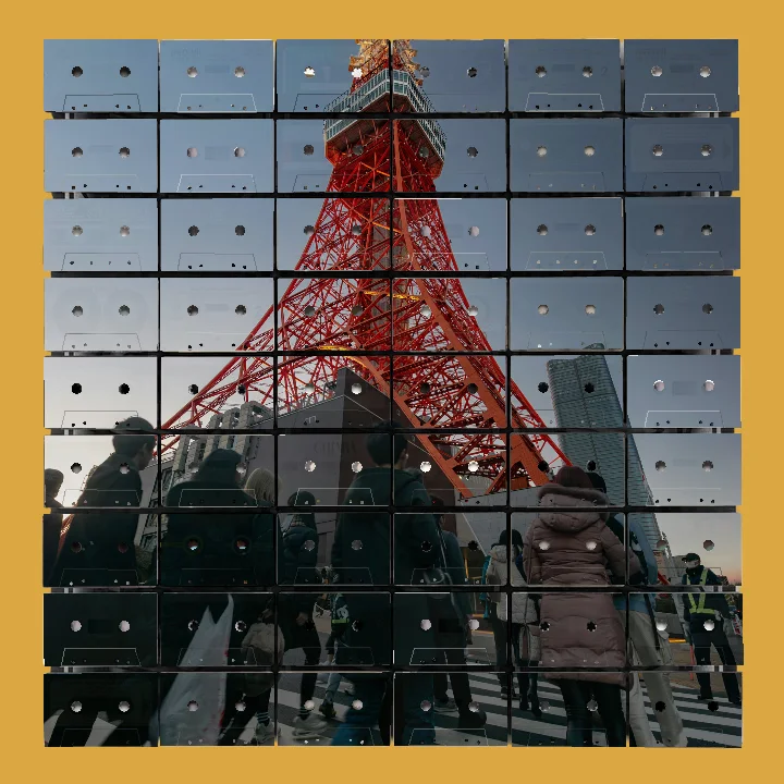 View from ground level of people walking across a striped pedestrian crosswalk with the red steel Tokyo Tower rising prominently in the background under a clear evening sky.
