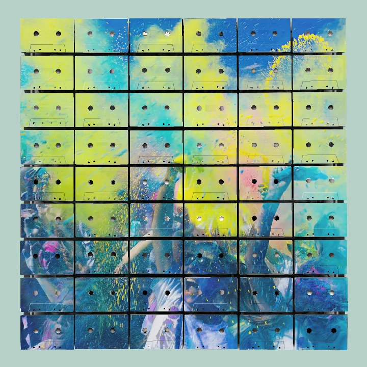 Crowd of people throwing yellow and blue powder in the air during a colorful celebration under a blue sky.